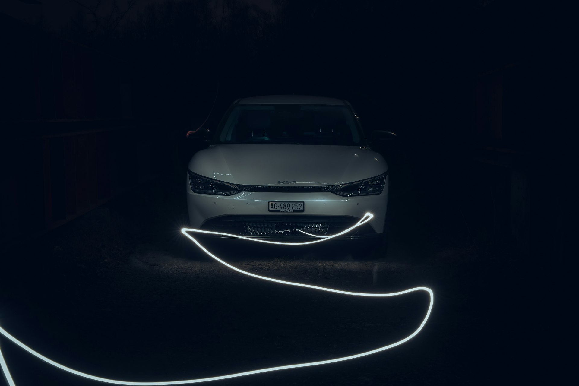 a car is parked in the dark with its headlights turned on